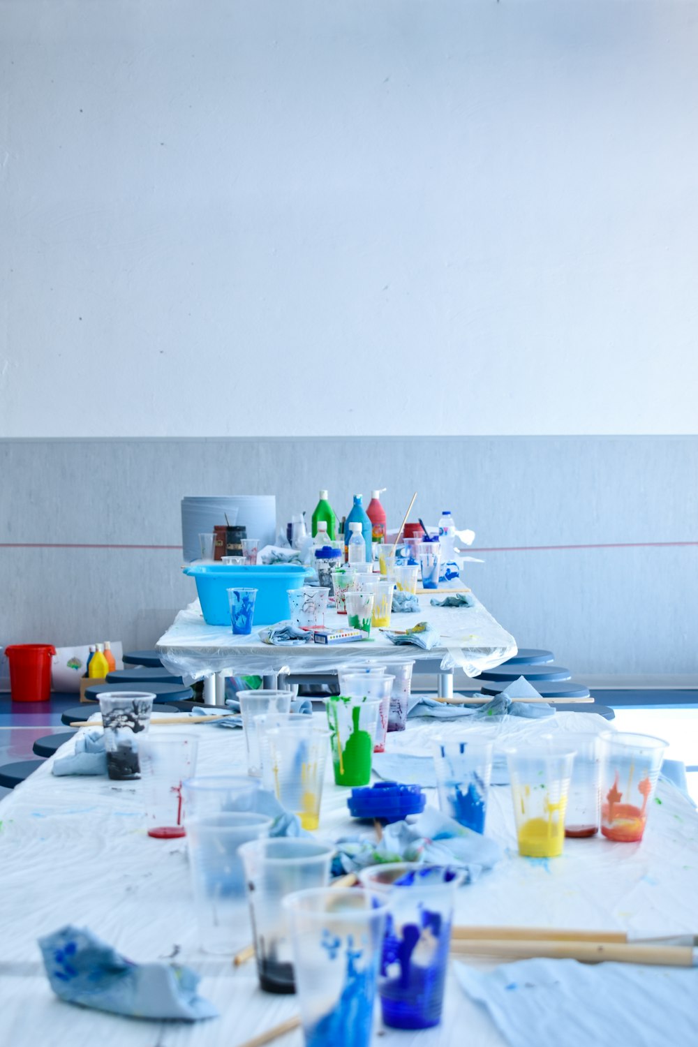 a long table covered with lots of paint and brushes