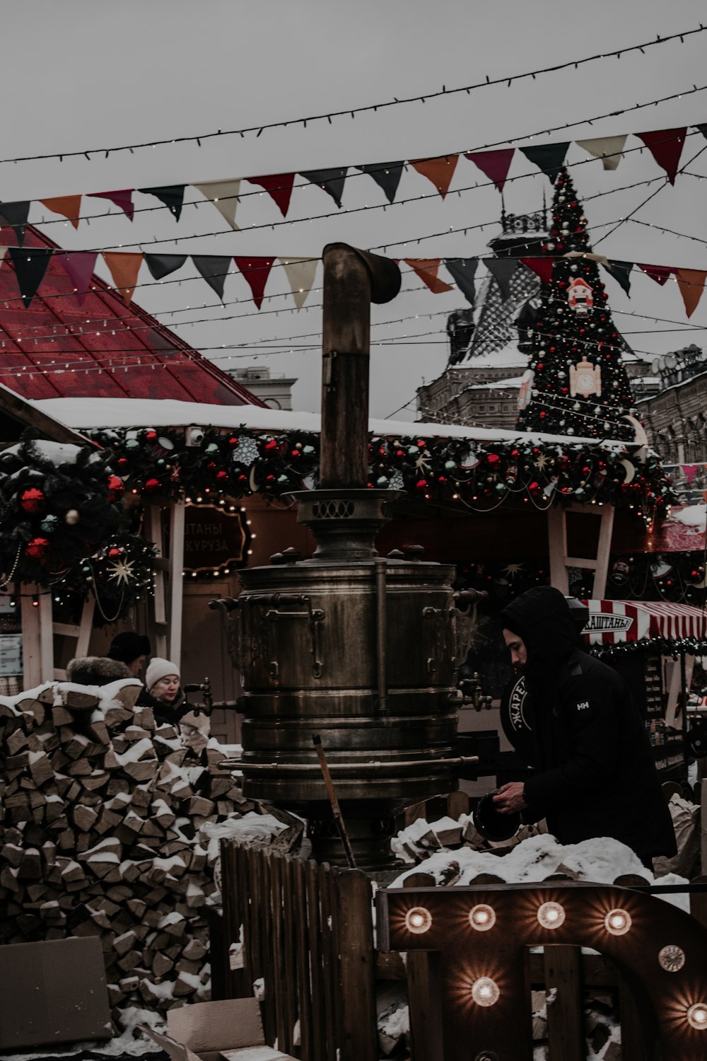 a person standing in front of a bell in the snow