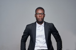 a man in a suit and glasses posing for a picture