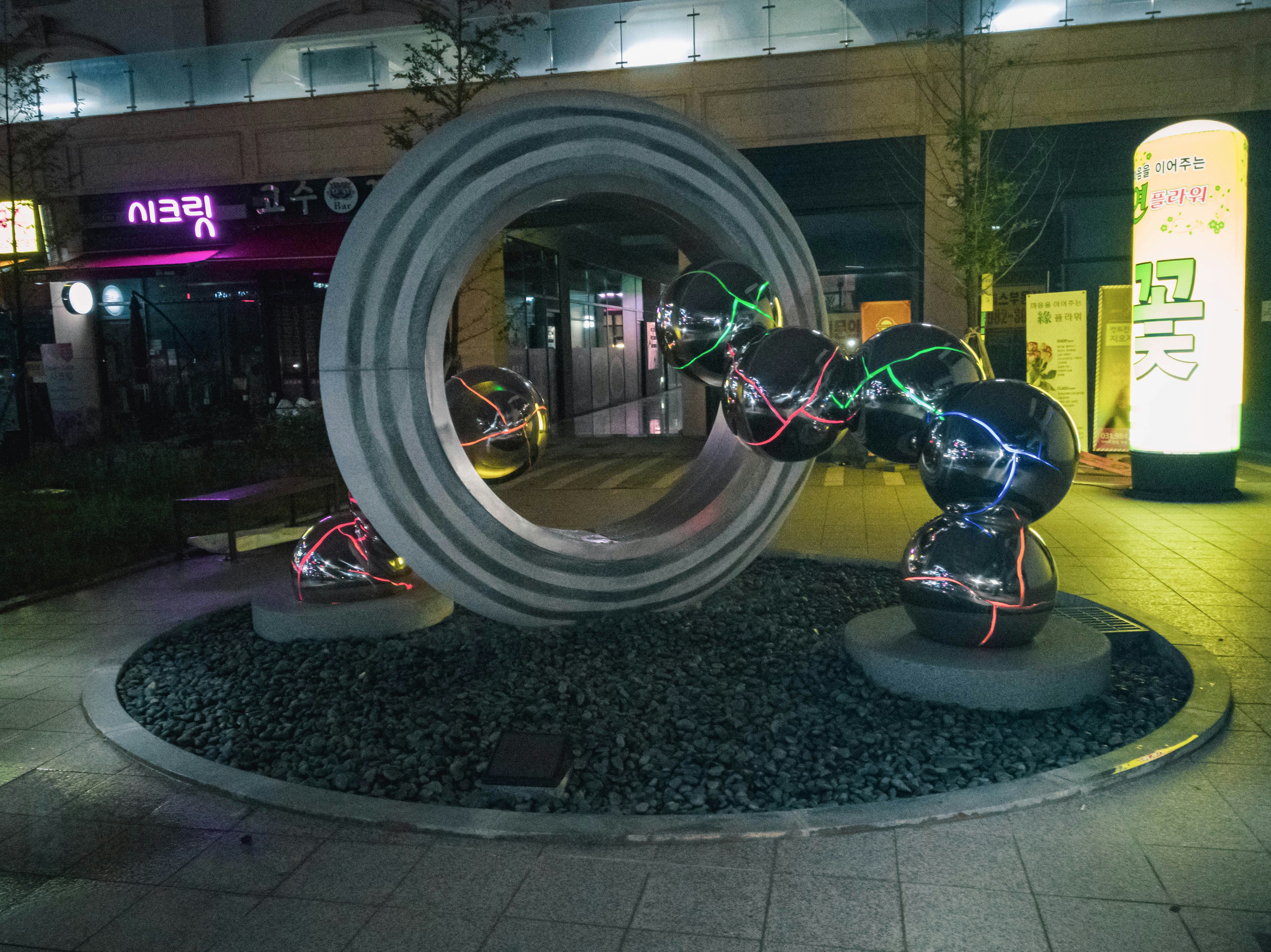 a sculpture in the middle of a street at night