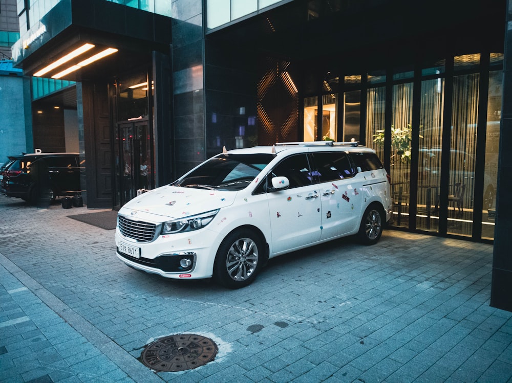 a white car parked in front of a building