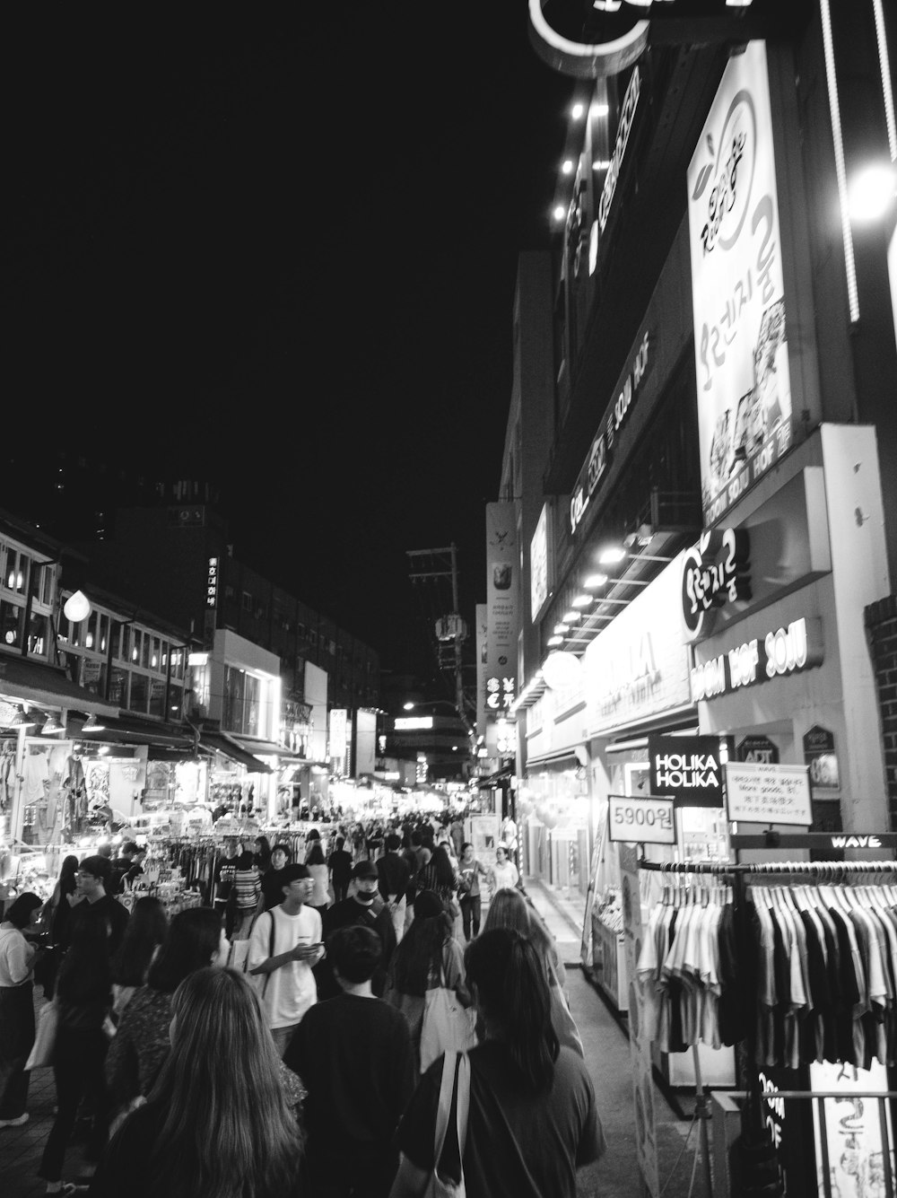 a crowd of people walking down a street at night