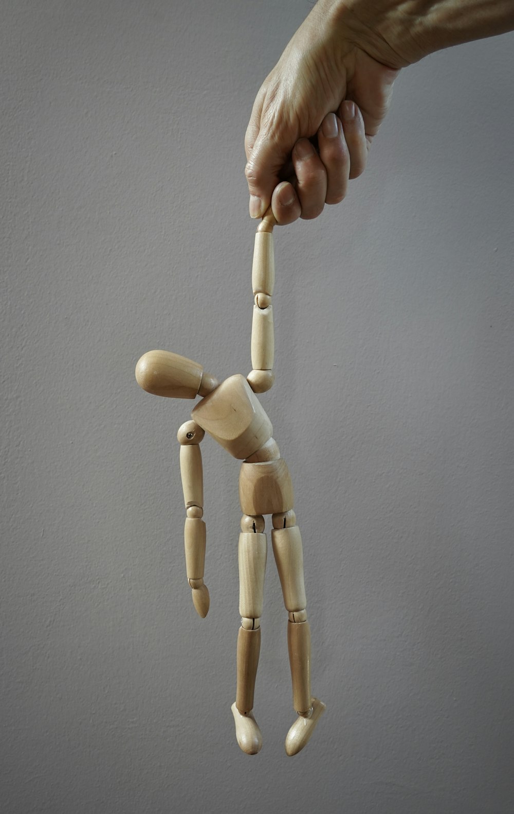 a wooden dummy being held by a hand