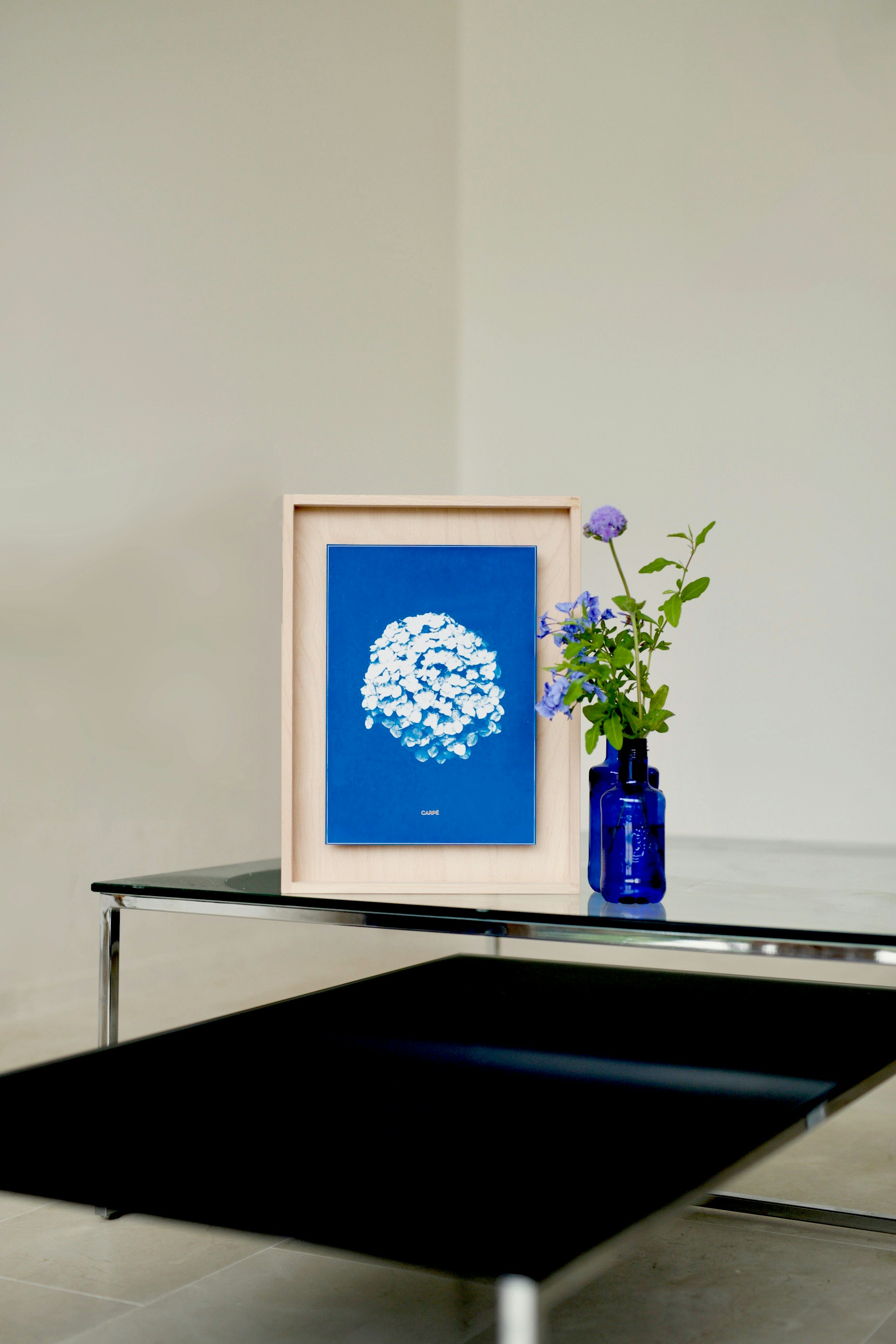 a blue vase with a flower in it sitting on a table