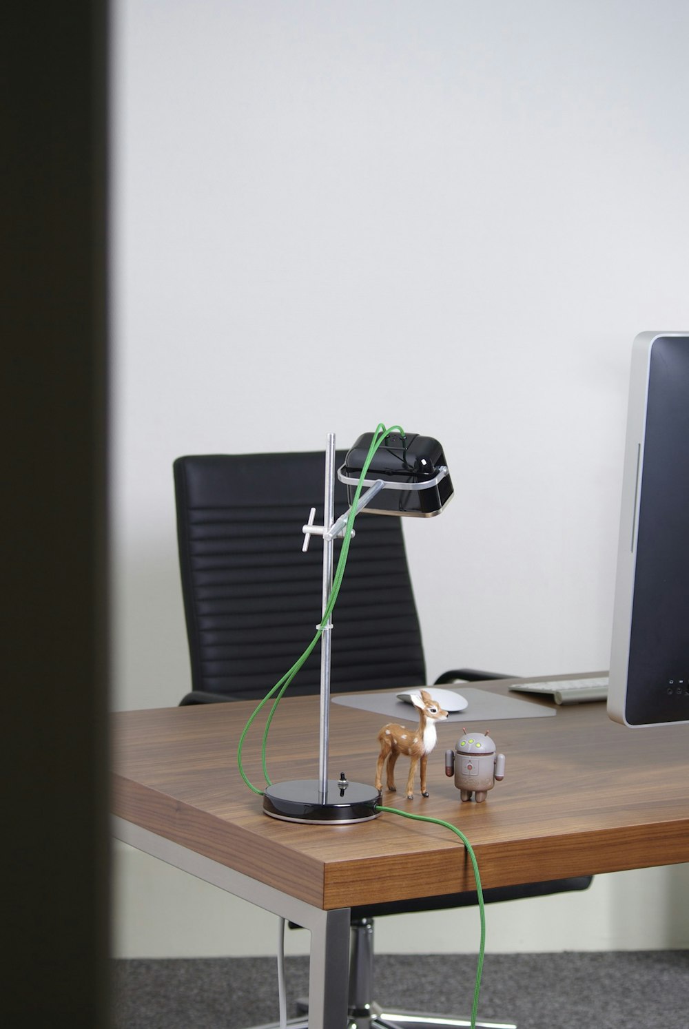 a desk with a computer and a lamp on it