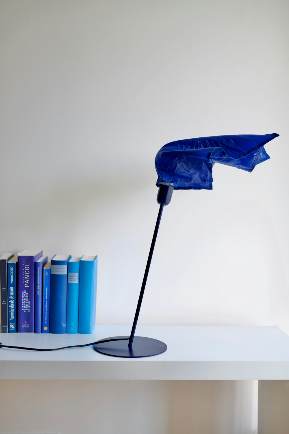 a blue umbrella on a table next to books