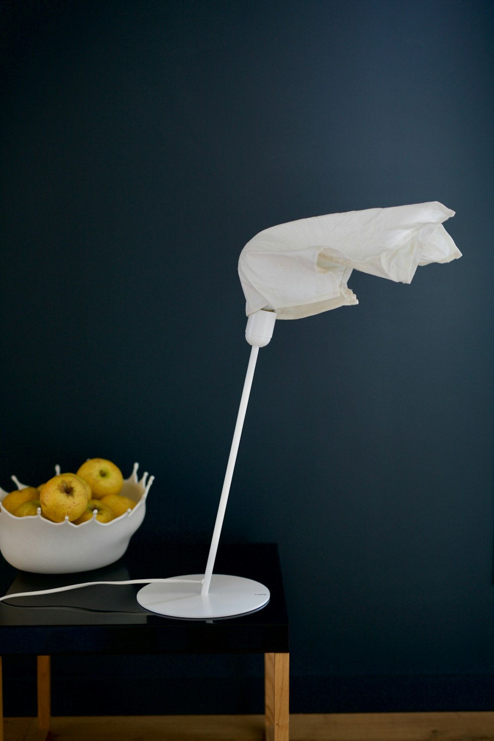 a table with a bowl of fruit and an umbrella