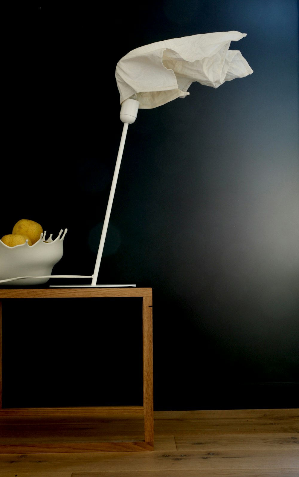 a bowl of lemons and an umbrella on a table