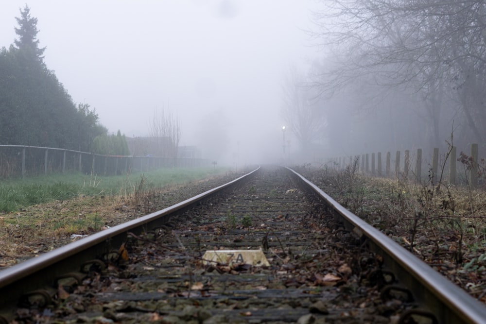 a train track in the middle of a foggy day