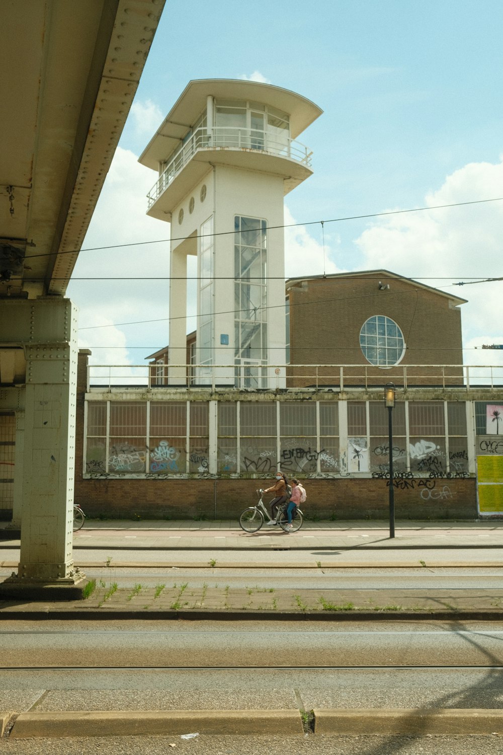 a man riding a bike down a street next to a tall building