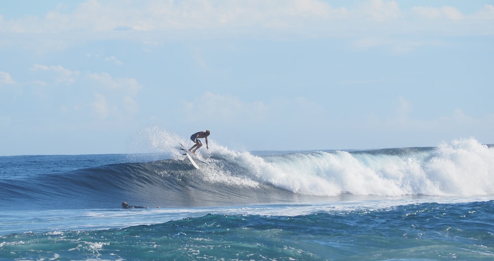 a man riding a wave on top of a surfboard