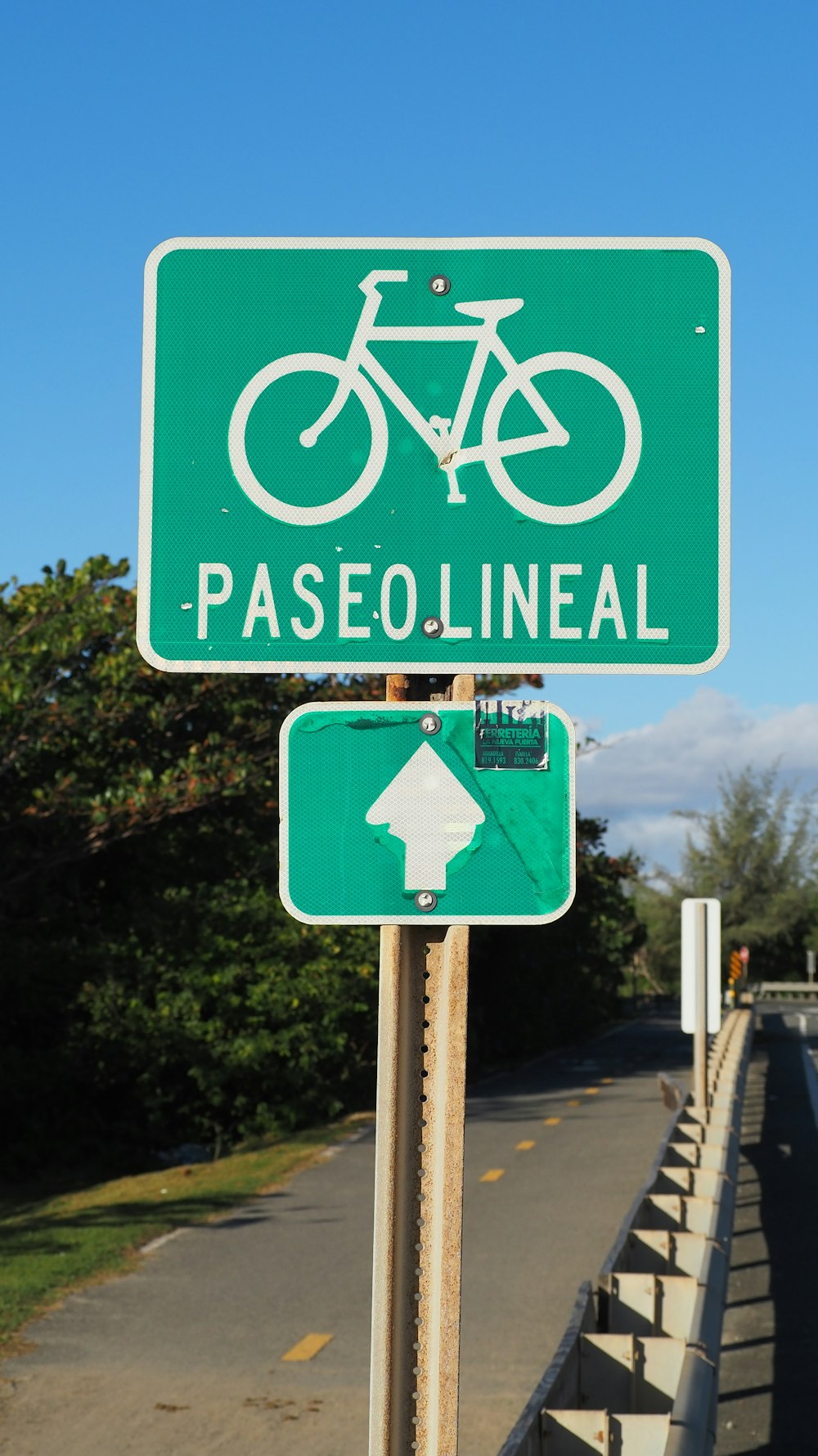 a green street sign with a bicycle on it