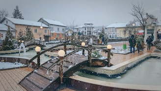 a group of people walking across a snow covered bridge