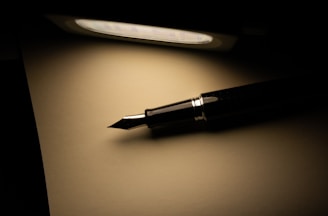 a pen sitting on top of a table next to a light