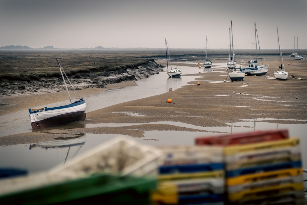 a group of boats sitting on top of a sandy beach