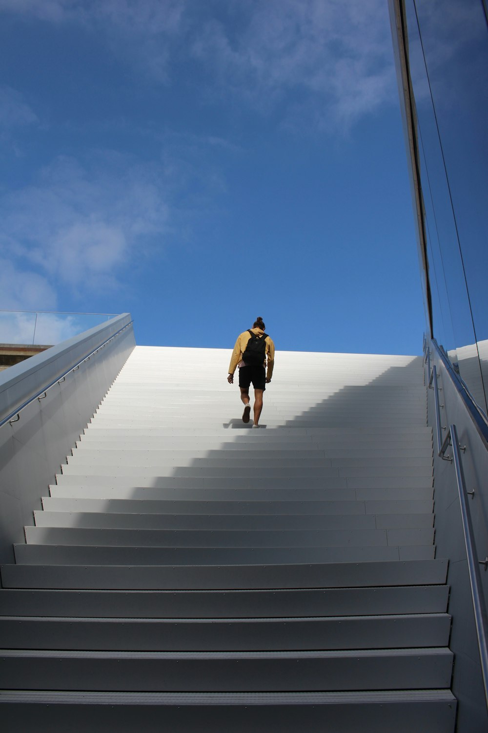 a man with a surfboard walking up a flight of stairs