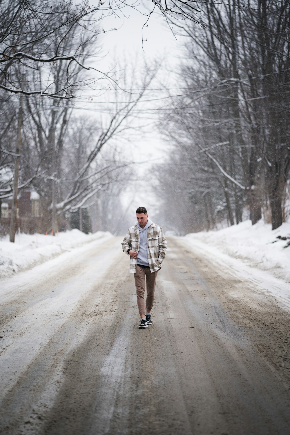 a man walking down a snow covered road