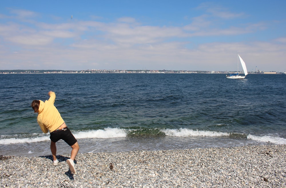 Ein Mann wirft einen Frisbee an den Strand