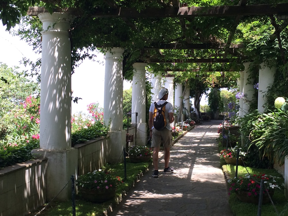 a man with a backpack walking down a walkway