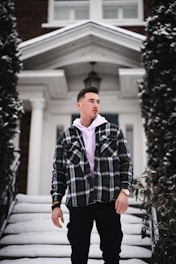 Jeremy Lundgren examining a home’s foundation, clipboard in hand, dressed in smart business casual.