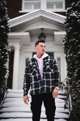 Jeremy Lundgren examining a home’s foundation, clipboard in hand, dressed in smart business casual.