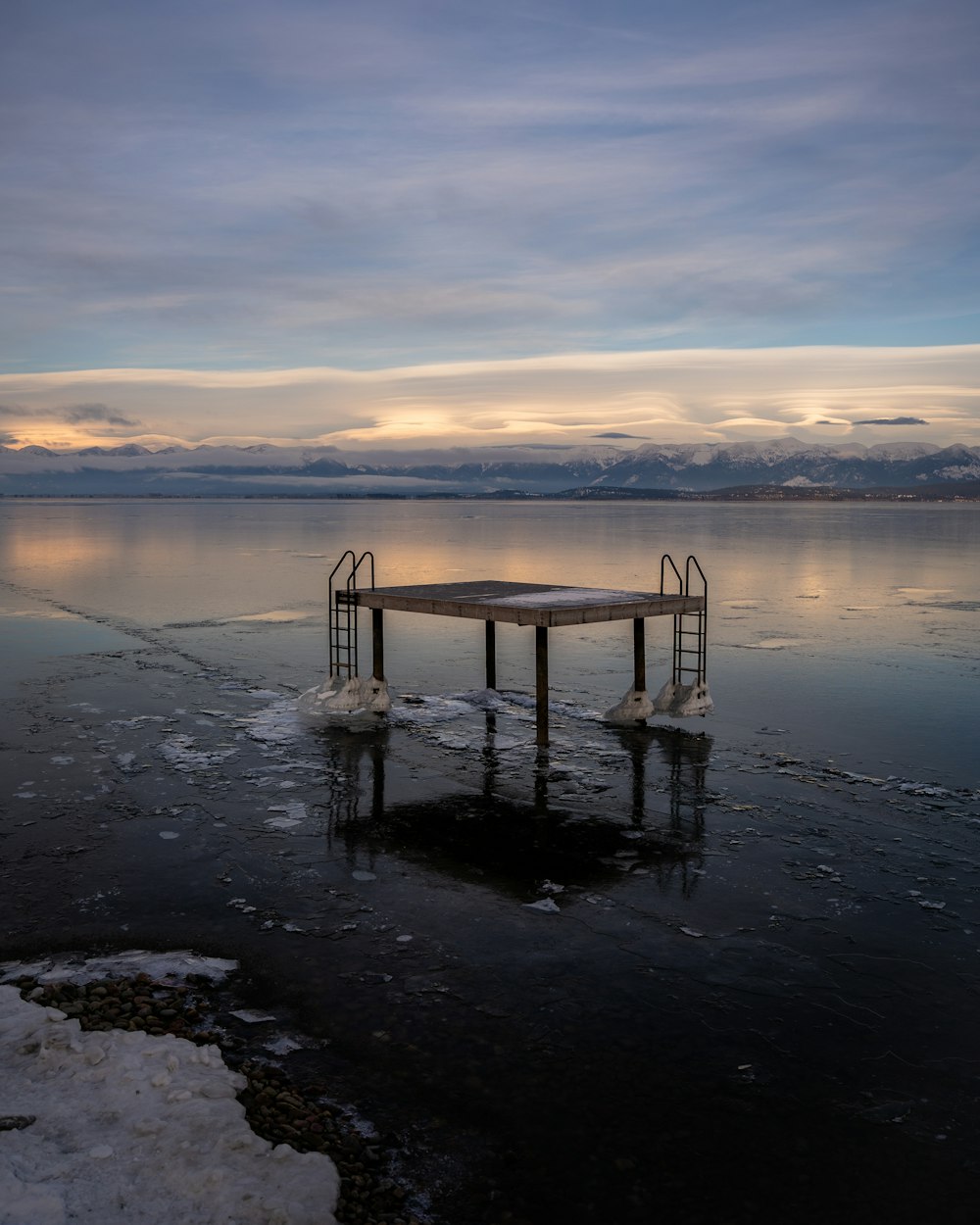 a dock in the middle of a frozen lake