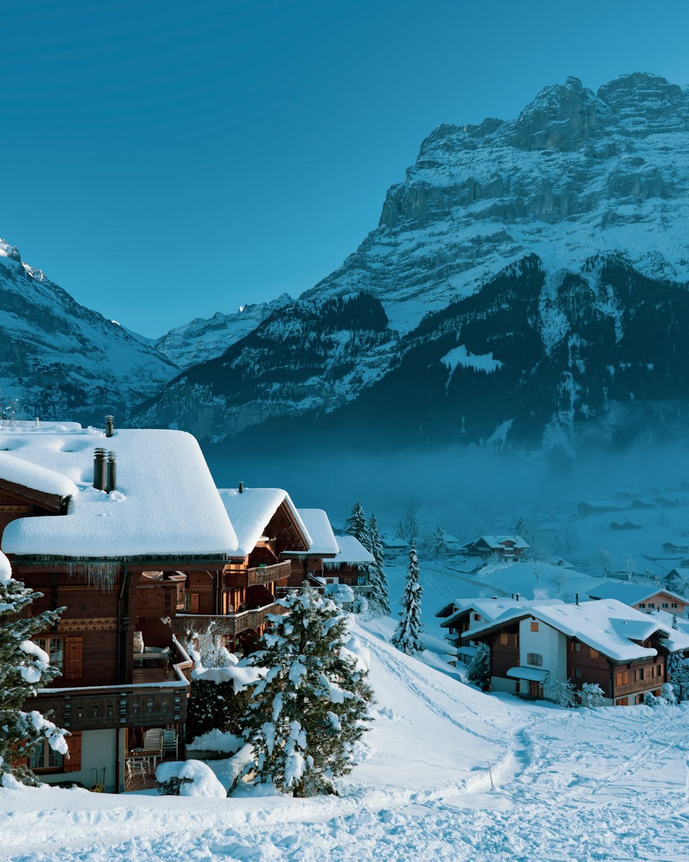 a snow covered mountain with a house in the foreground