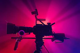 a camera on a tripod in front of a red and purple background