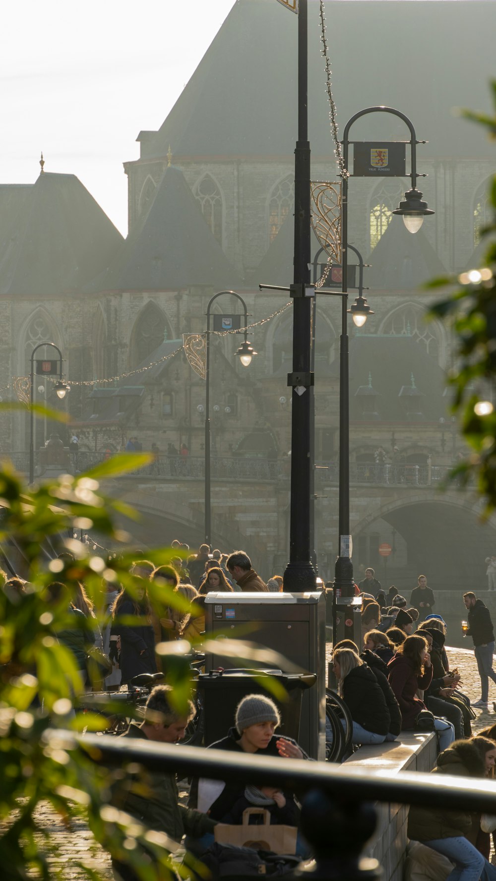 a group of people sitting on a bench next to a street light