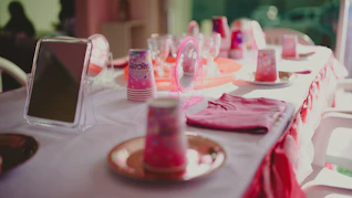 a table set up for a party with pink decorations