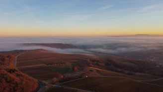 A panoramic view of the NA Farmhouse plots showcasing the peaceful, fog-kissed environment
