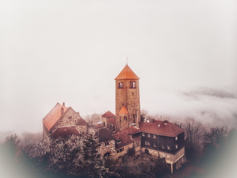 an aerial view of a church in the fog