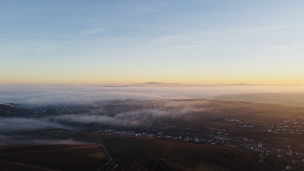 an aerial view of a town and a valley covered in fog