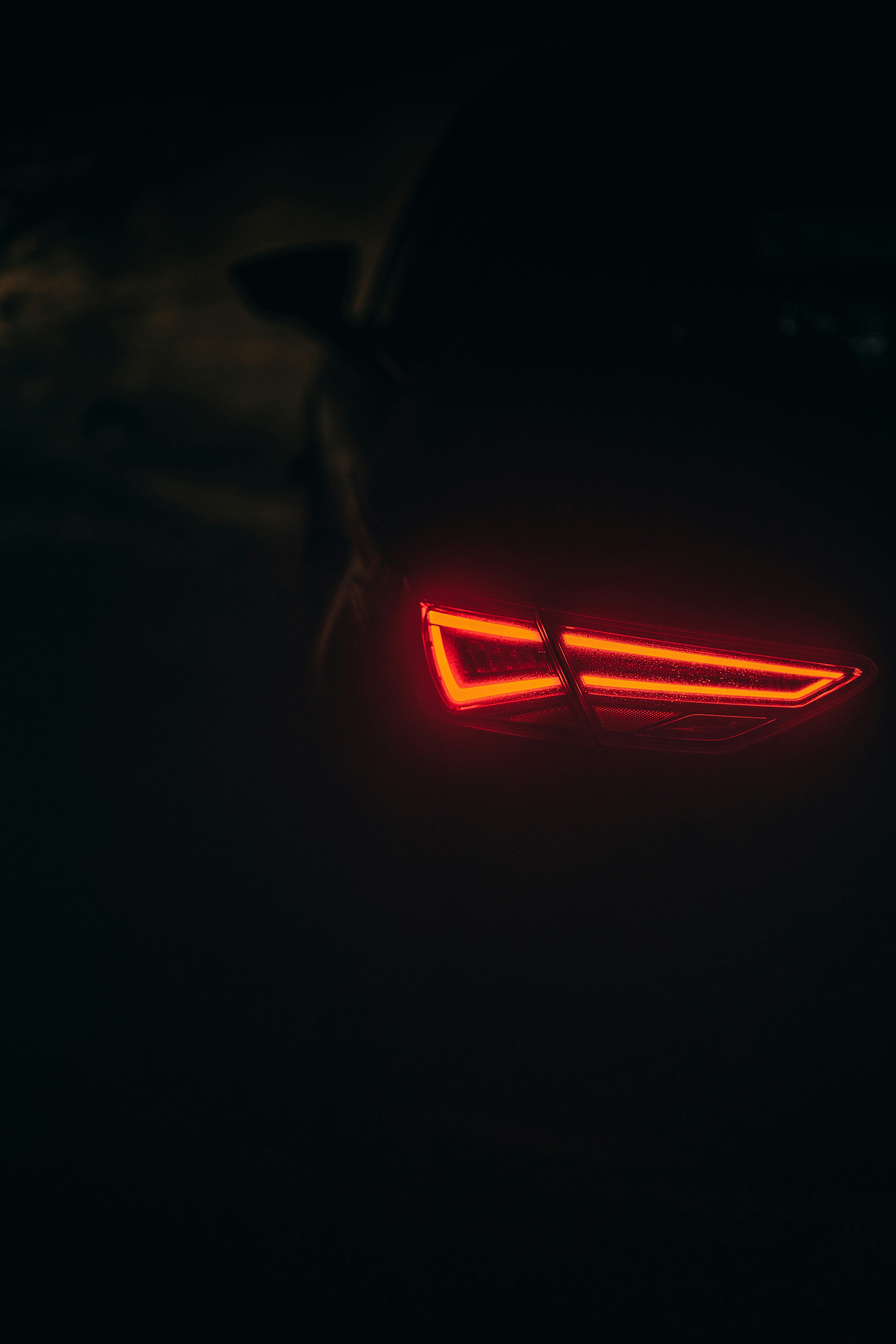 Le feu arrière d’une voiture dans l’obscurité