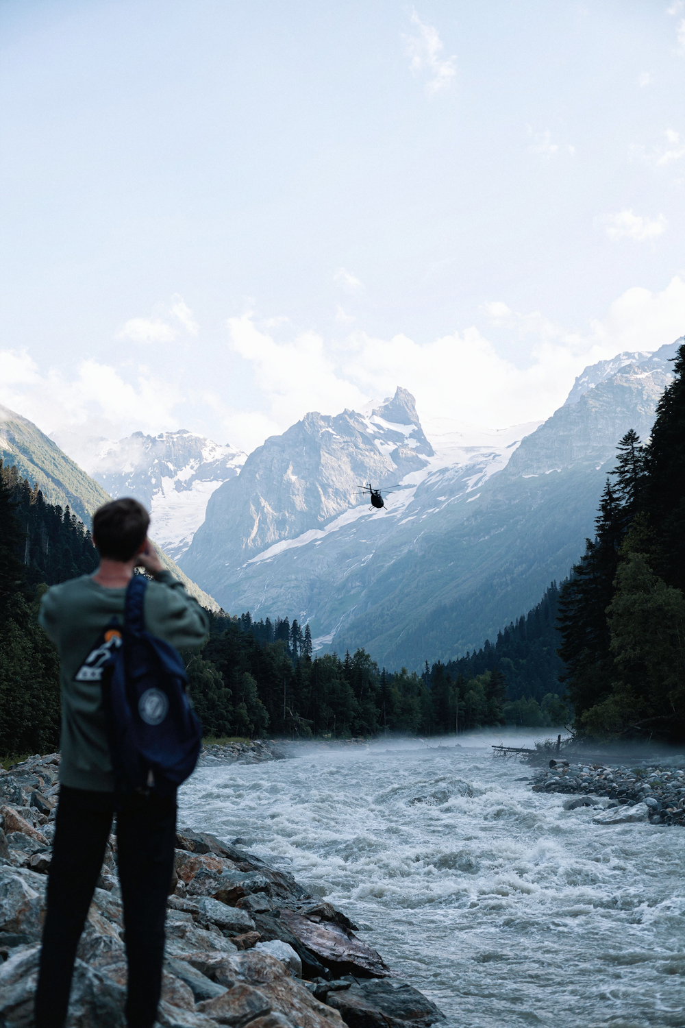 a man standing on a rock next to a river