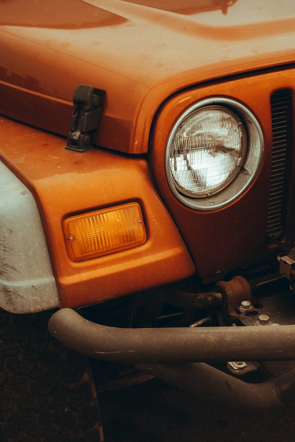 a close up of the front end of an orange truck