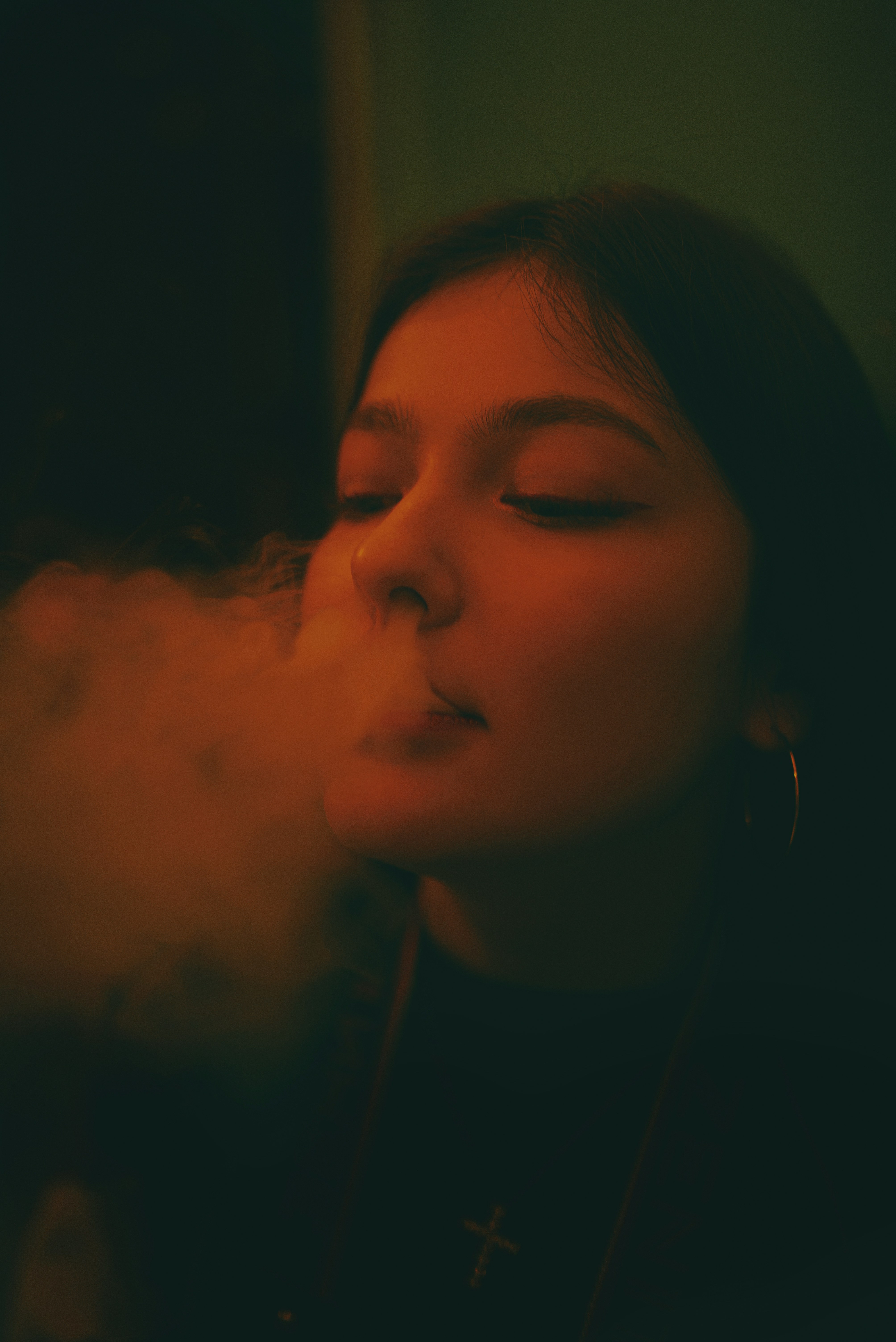 a woman smoking a cigarette in a dark room