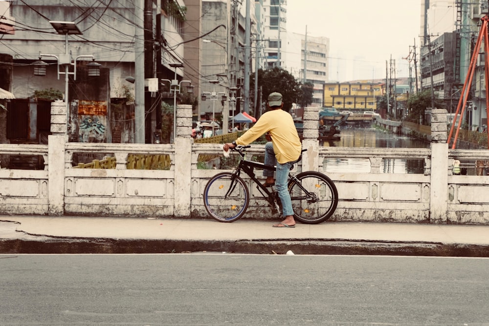 a man riding a bike down a street next to tall buildings