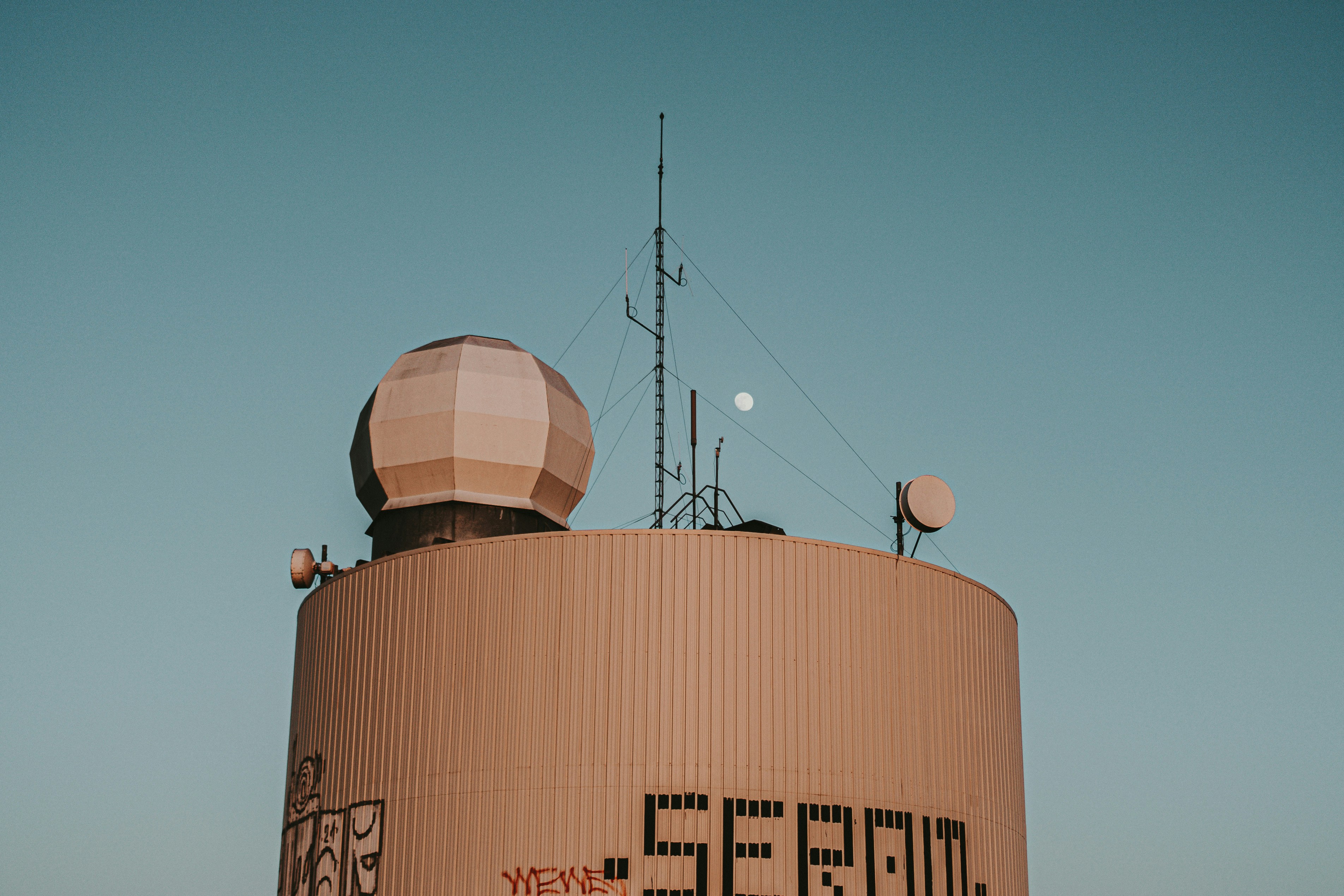 a large brown building with a satellite dish on top of it