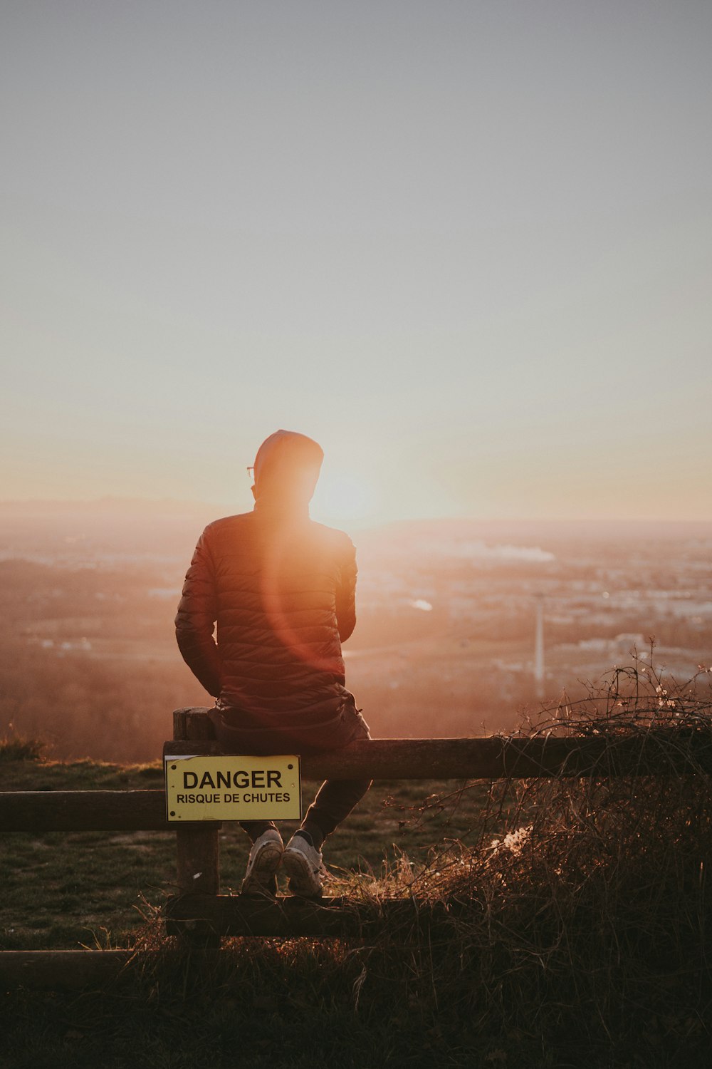 a man sitting on top of a wooden bench