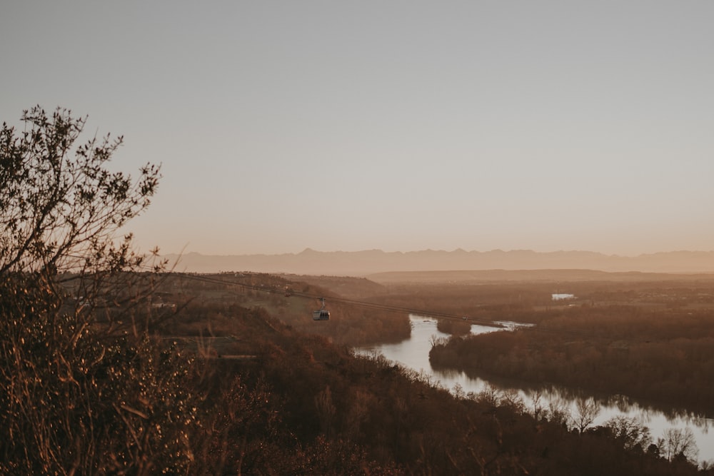 a river running through a dry grass covered field