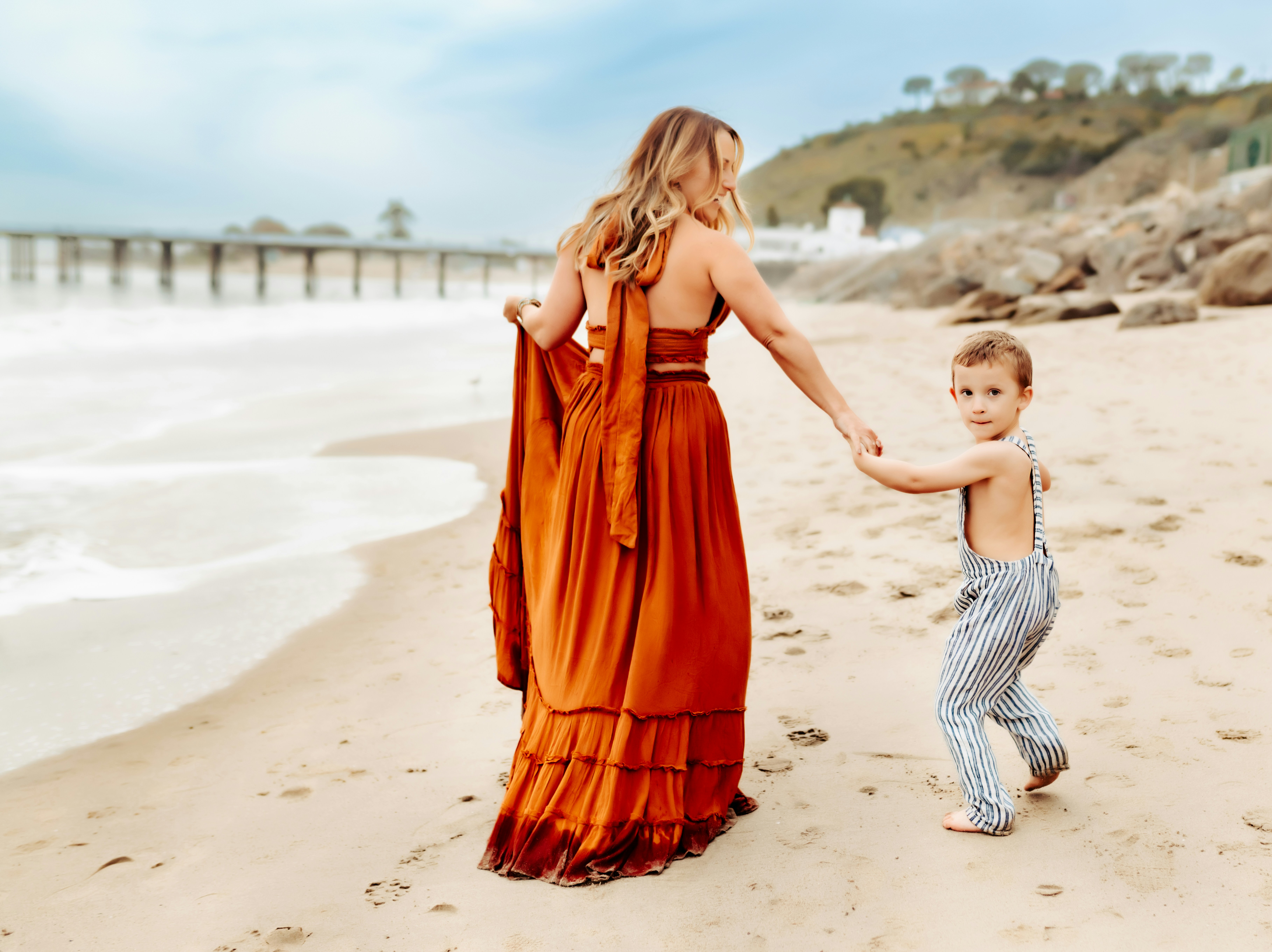 Une femme et un enfant se tenant la main sur une plage
