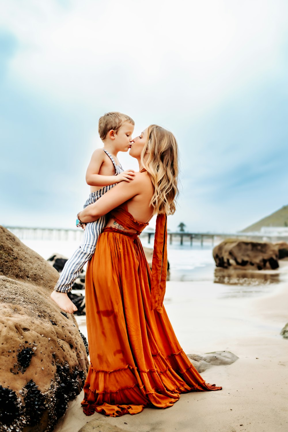 a woman holding a boy on the beach
