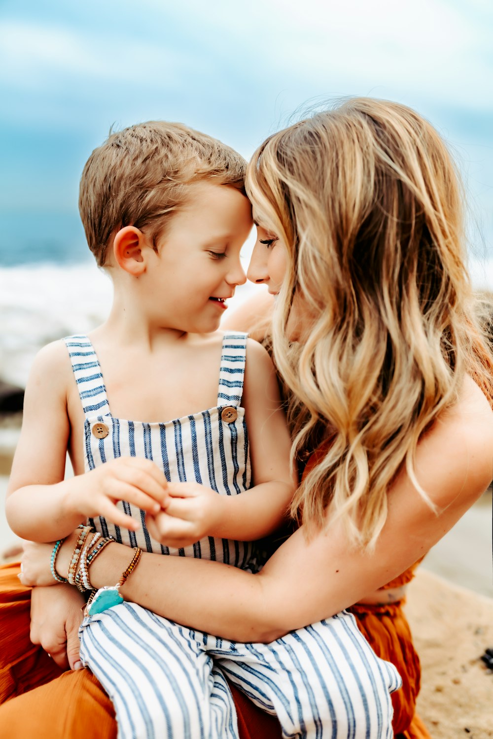 a woman and a child sitting on a beach