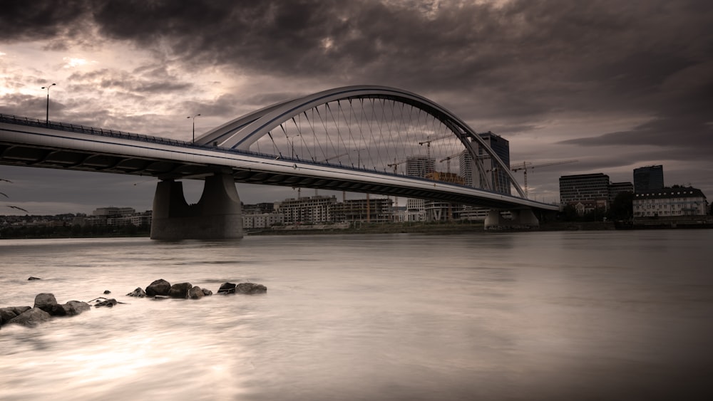 a bridge over a body of water under a cloudy sky