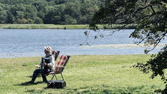 A warm photo of Maria Peçanha playing accordion outdoors, surrounded by nature and traditional gaucho elements.