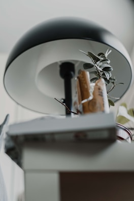 A sleek modern lamp casting warm light over a minimalist desk setup with a few tasteful decor accents.