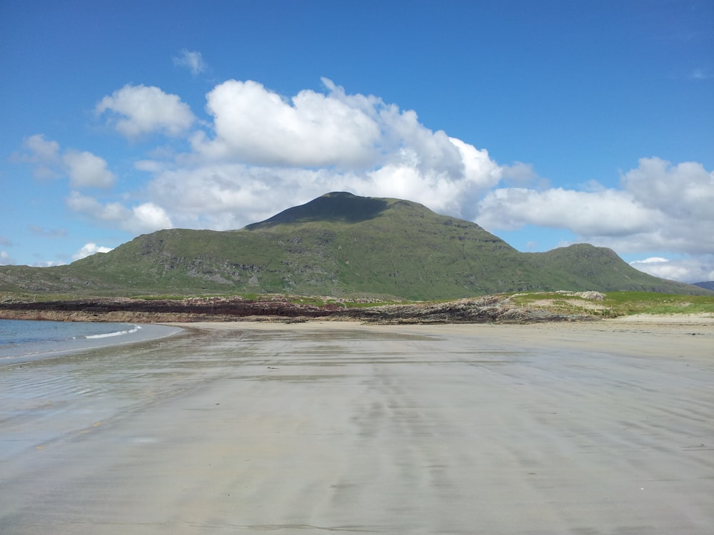 Una playa de arena con una montaña al fondo