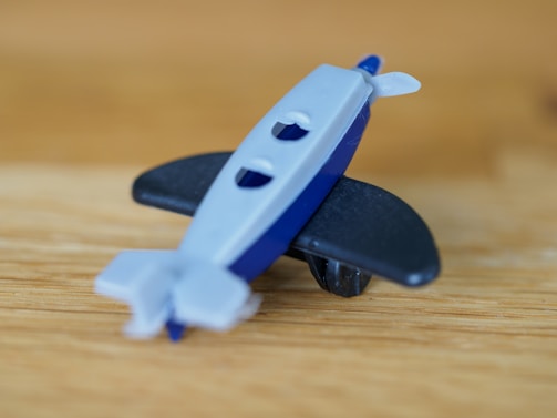A child playing with a detailed toy airliner on a runway playmat, eyes wide with wonder.