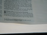 A close-up view of a book page displaying text in two columns. The heading 'The king's edict on behalf of the Jews' is bolded, and part of the biblical text from the book of Esther is visible, including prominent numbering at the start of a section.